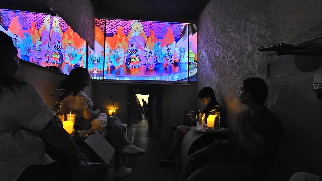 d-stellar's crowd watching the La Más Draga 2 live broadcast projected on the big screen